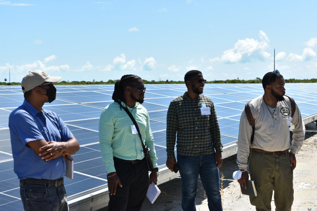 people standing in front of solar panels