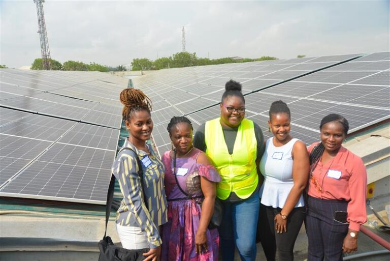 Group of women standing in front of solar panels